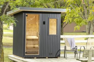 finnleo northstar outdoor sauna cabinet on a wooden deck, surrounded by trees